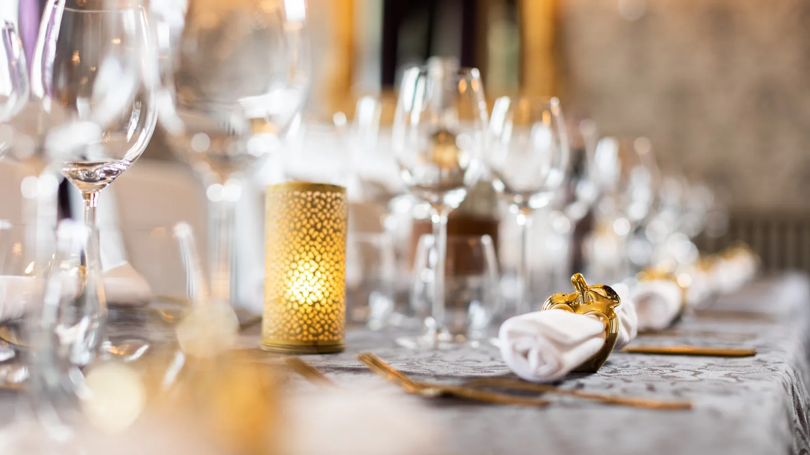 Een zorgvuldig gedekte dinertafel met glazen en kaarslicht