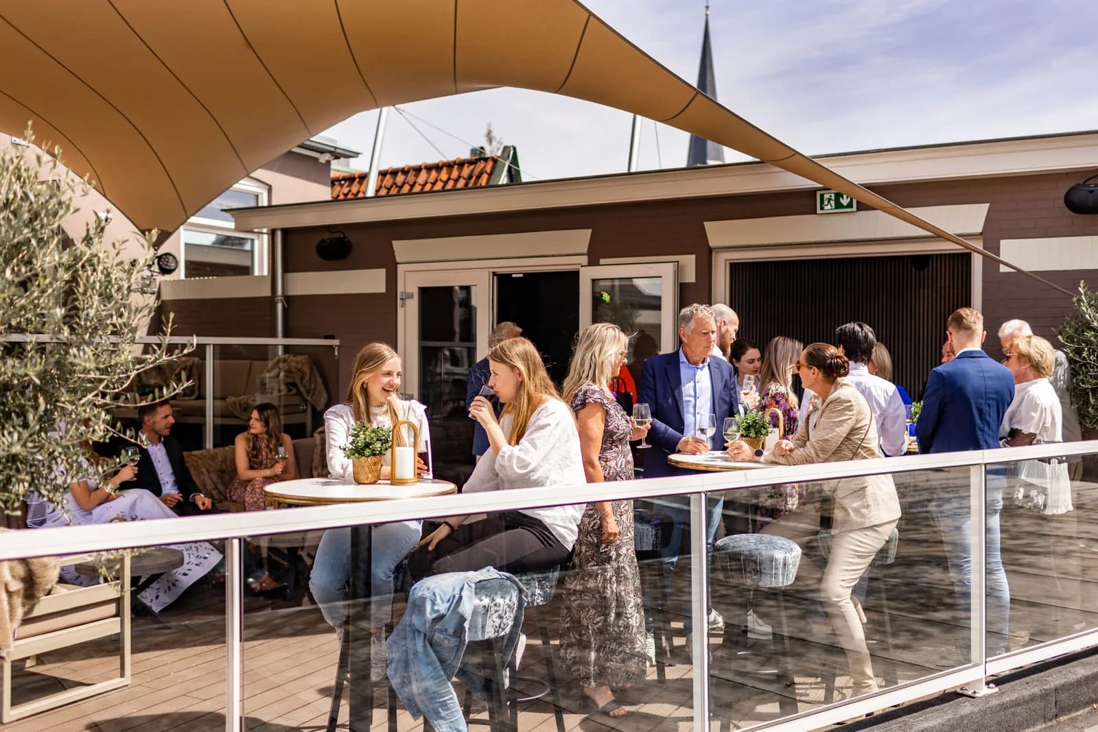 Gasten genieten samen van een borrel op het Bordes
